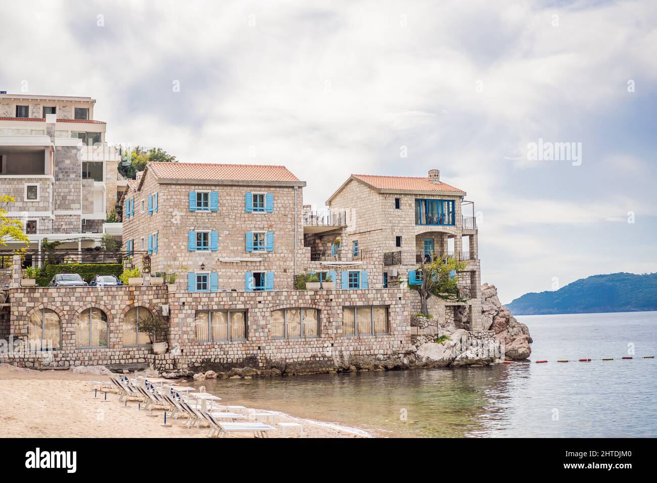 Picturesque summer view of Adriatic sea coast in Budva Riviera near Przno village. Cozy beach and buildings on the rock. Location: Przno village Stock Photo