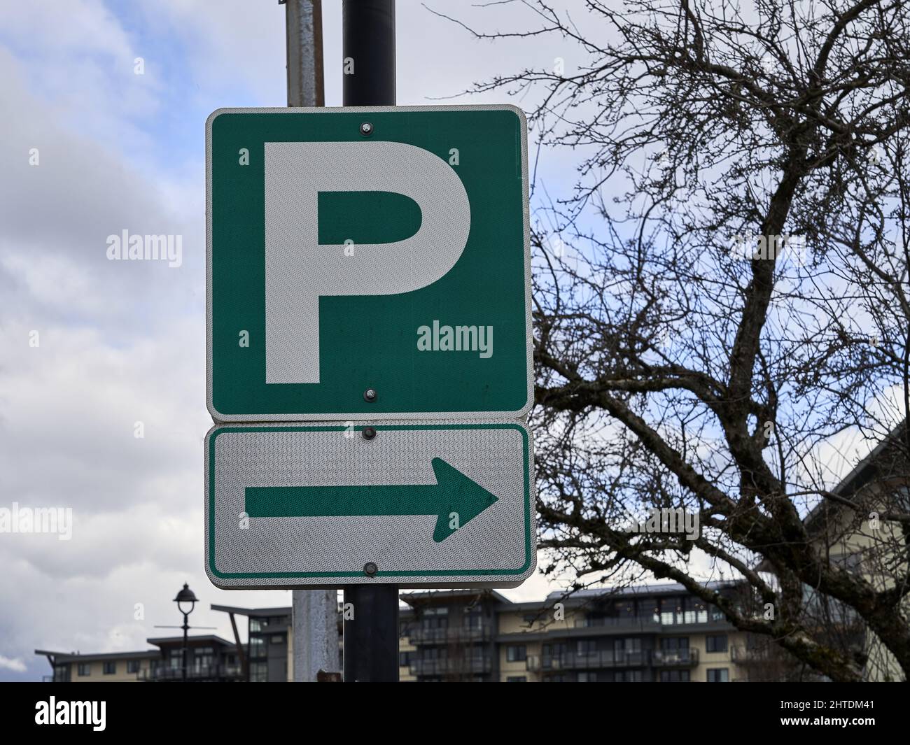 Green and white parking lot sign with the letter P and an arrow showing