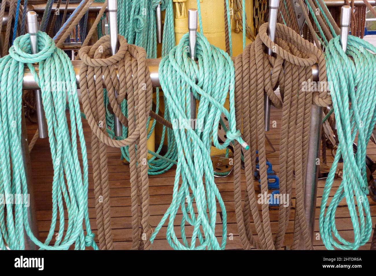 Closeup shot of ropes hanging on hooks of sailing ship Stock Photo