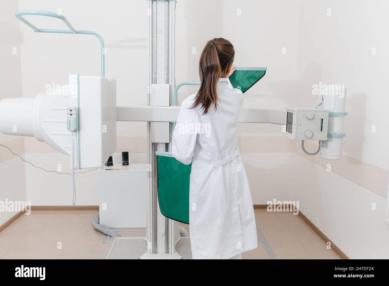 Hospital Radiology Room. Xray machine for fluorography. Doctor radiologist in gown adjusting the