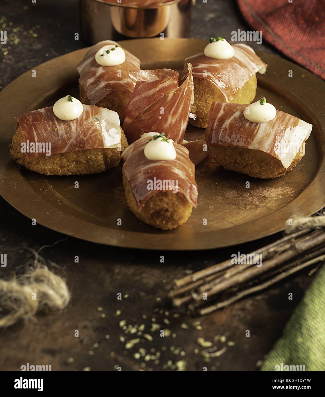 Closeup of Iberian ham croquettes with thin slices on top and kimchi