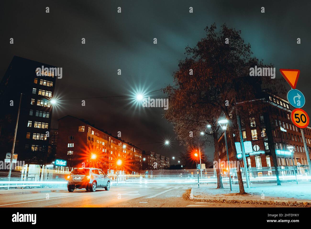 Shot of buildings and a road illuminated by traffic lights at night in