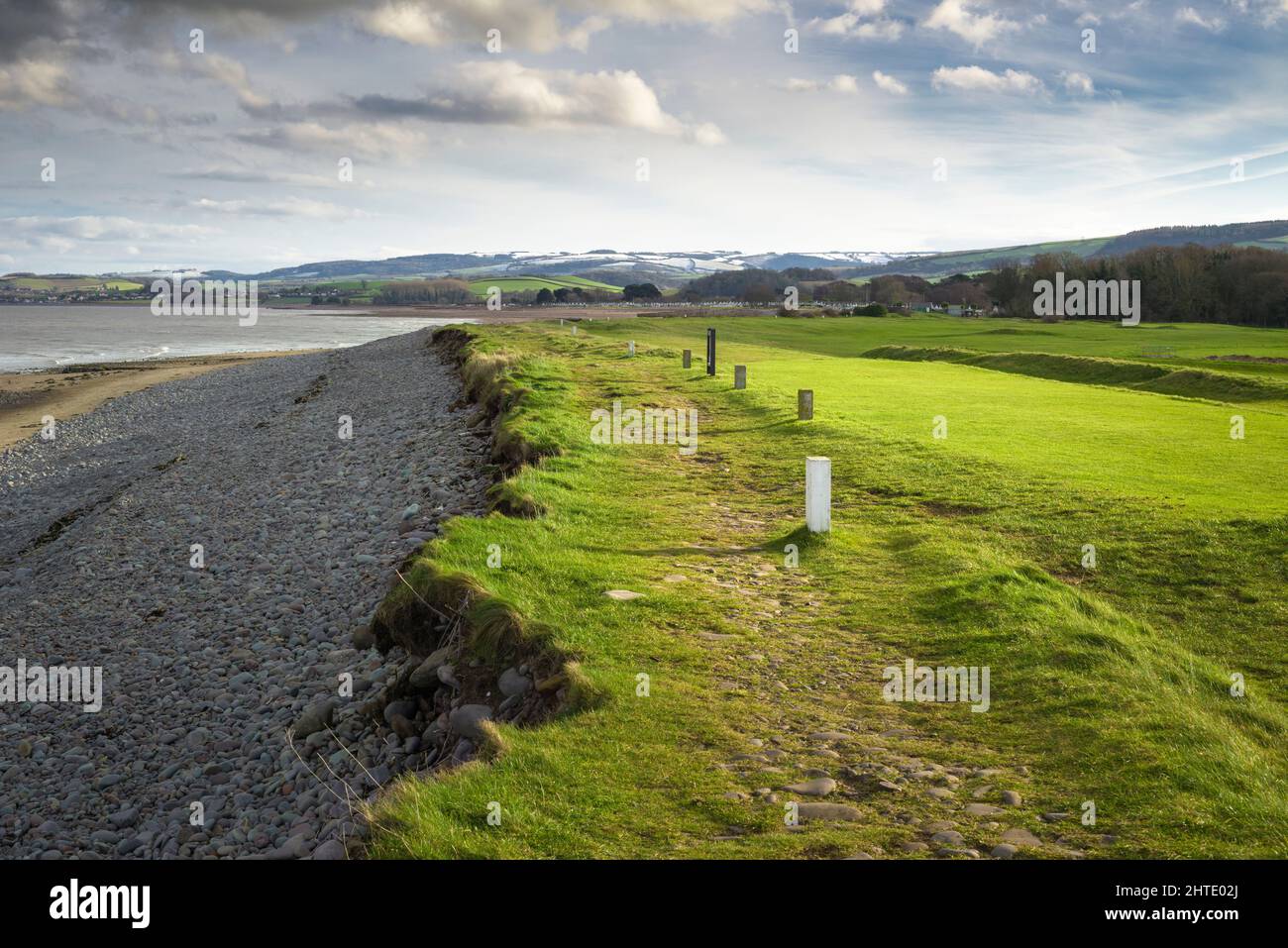 The West Somerset Coast Path alongside The Minehead and West Somerset Golf Club leading to Dunster Beach with the snow capped Quantock Hills beyond, Somerset, England. Stock Photo