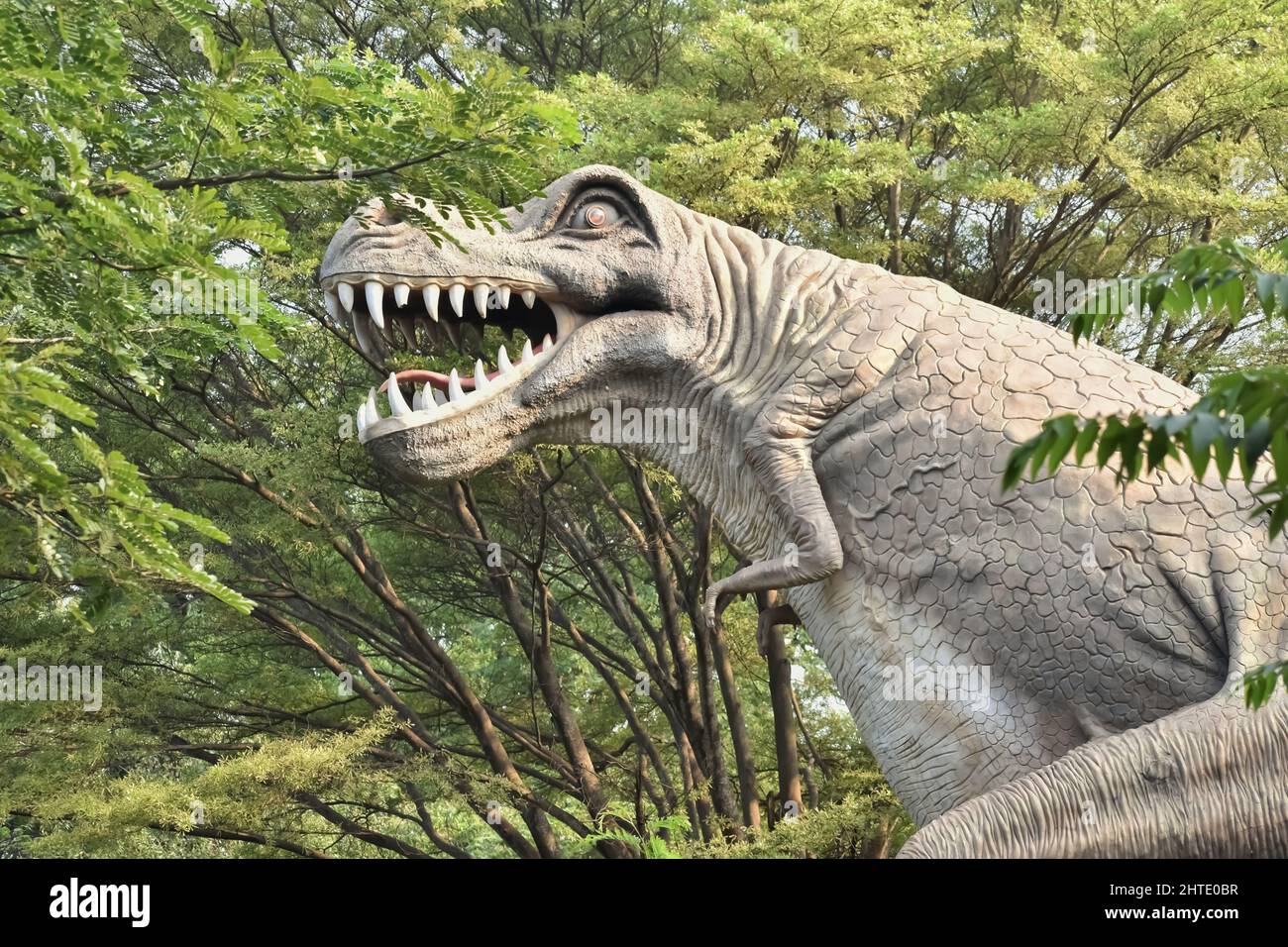 Dinosaur marionette surrounded by plants in a park in India Stock Photo ...