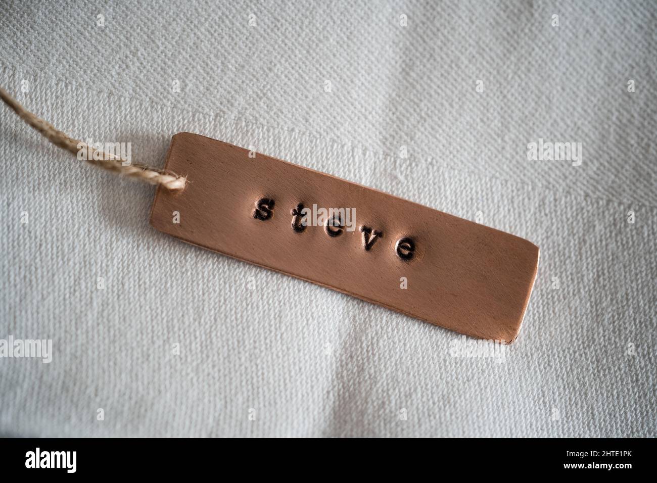 First name Steve identity engraved name dog tag copper metal name plate badge. Shiny and clean stamped letters on retro trinket pendent. Short Steven Stock Photo
