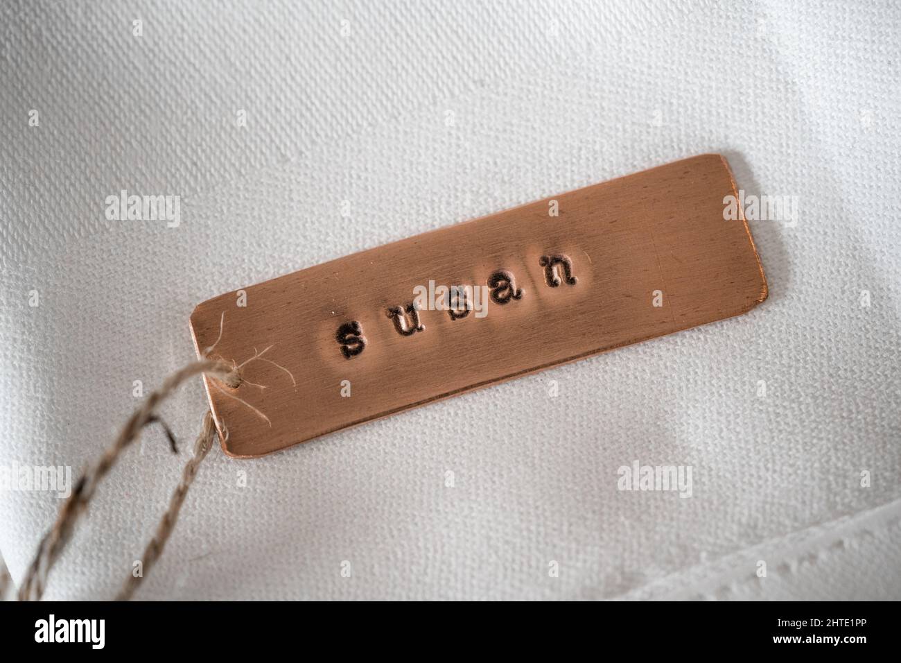 First name Susan identity engraved name dog tag copper metal name plate badge. Shiny and clean stamped letters on retro trinket pendent. Stock Photo
