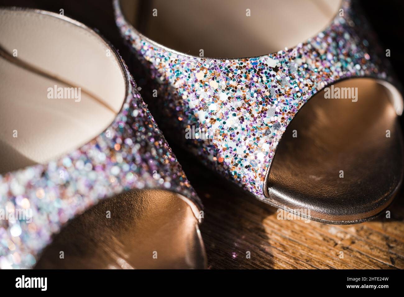 Beautiful glitter shoes close up macro of buckle clasp fastened.  Sparkly bright colours and gold fastener. Stock Photo