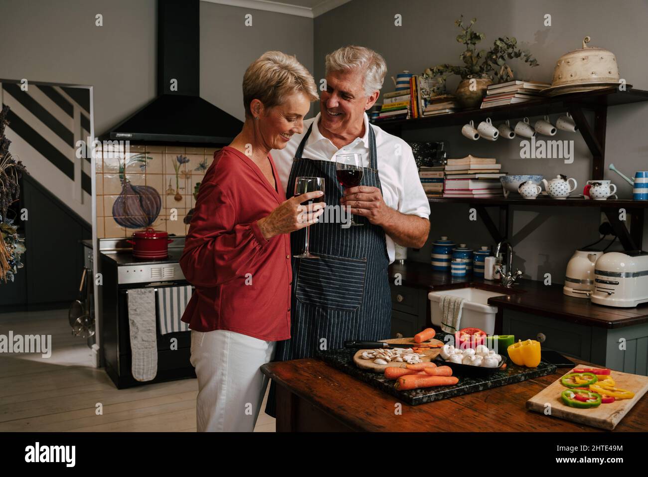 Caucasian elderly couple embracing while cooking in kitchen  Stock Photo