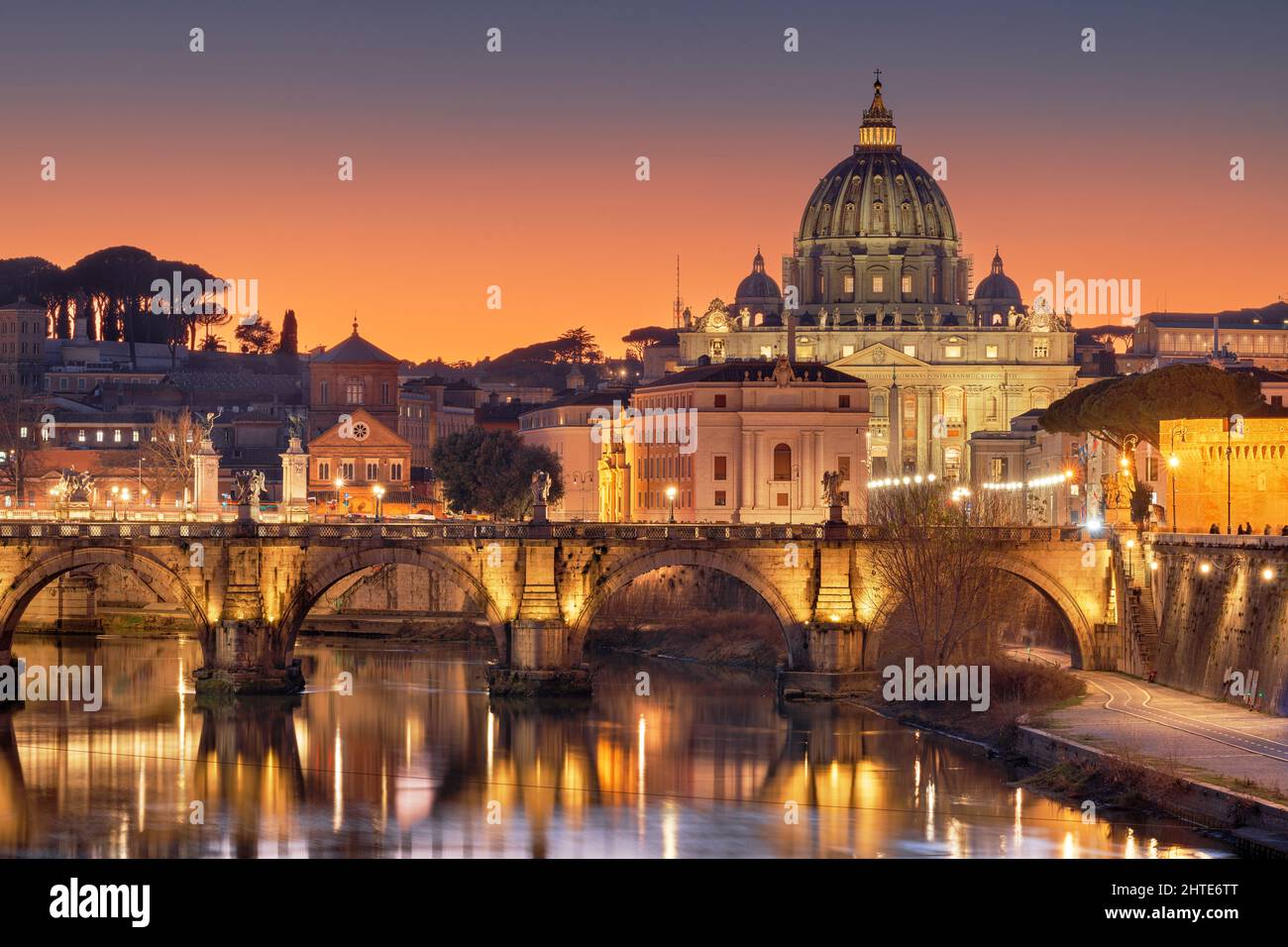 St. Peter's Basilica in Vatican City on the Tiber River through Rome, Italy at dusk. Stock Photo