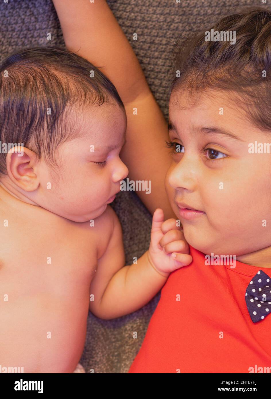 Happy indian toddler girl playing with her newborn sister Stock Photo -  Alamy, image size:944x1390