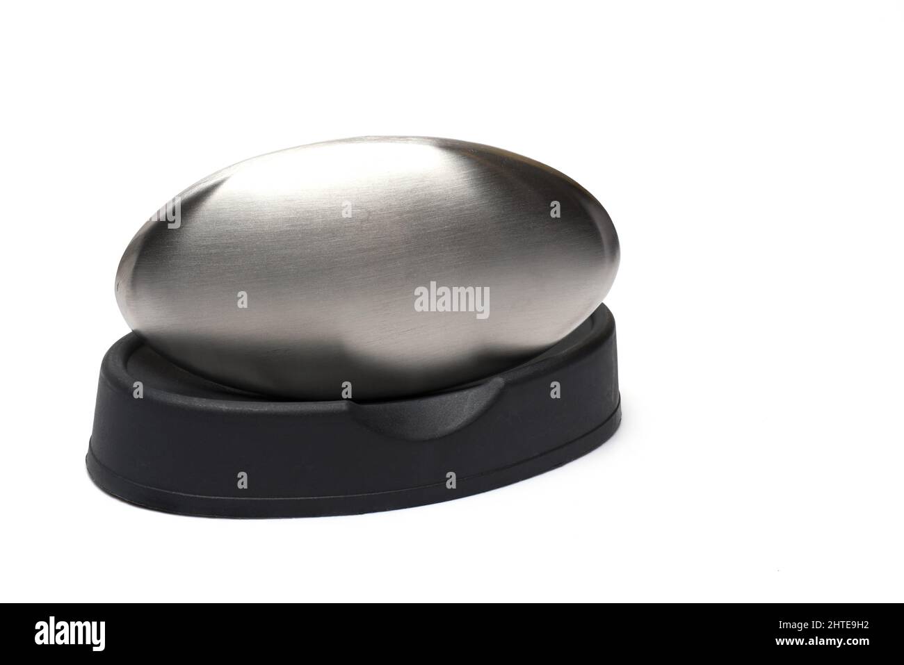 Close up of stainless steel bar of soap on black dish on white