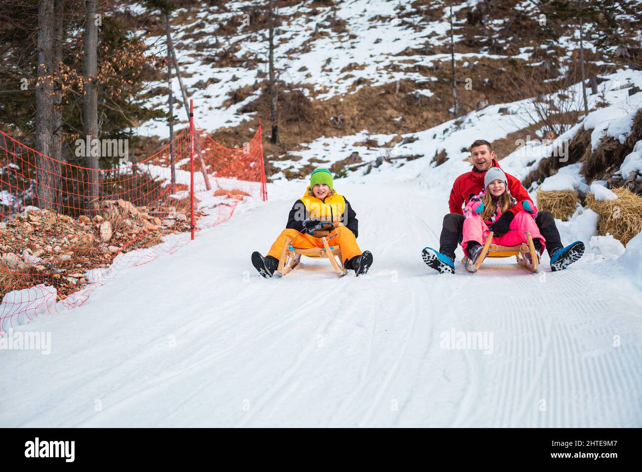 Family sledding on the snow and having fun in winter Stock Photo - Alamy