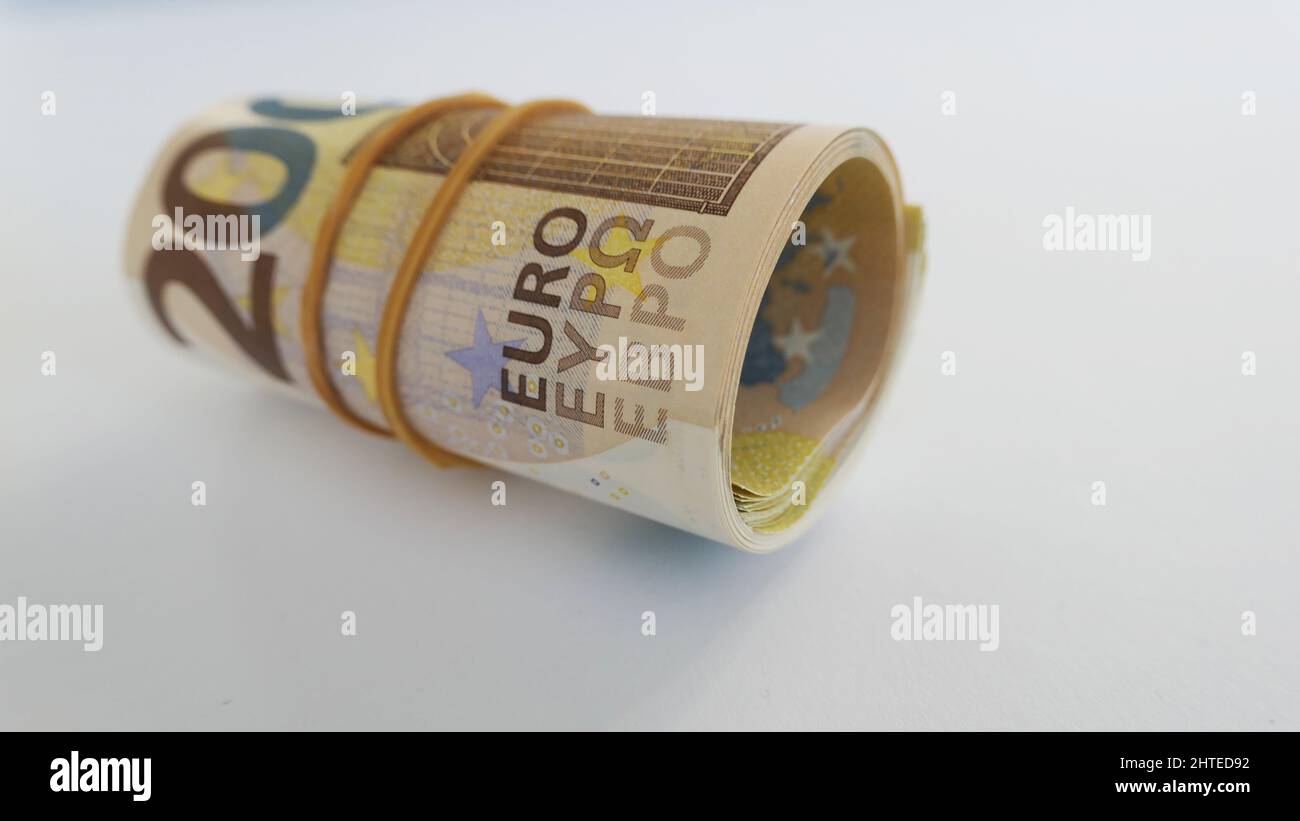 roll of 200 Euro notes with rubber band around - close-up isolated ...