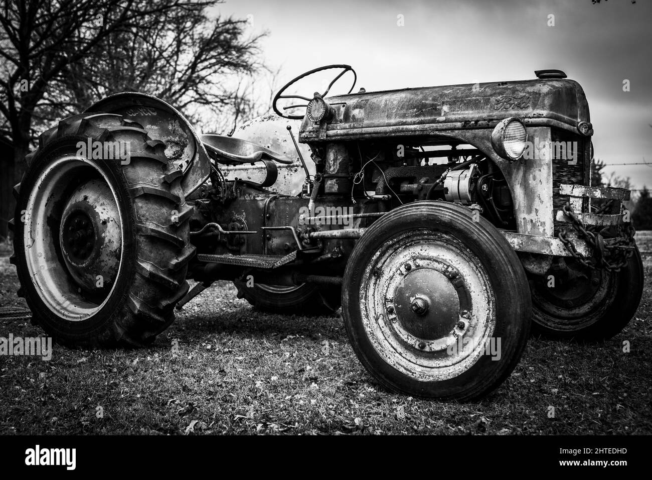 Grayscale shot of an old tractor with big wheels Stock Photo