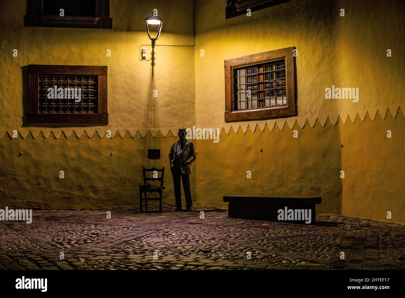 statue of nestor alamo early evening lit by street light outside columbus house in vegueta gran canaria Stock Photo