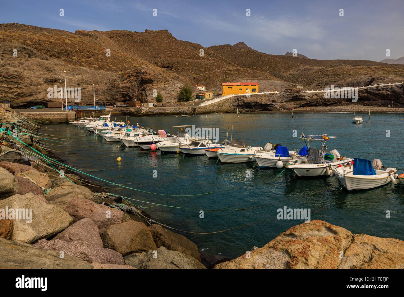 fishing boats line up in the calm sea of the natural harbour of puerto de la aldea gran canaria Stock Photo