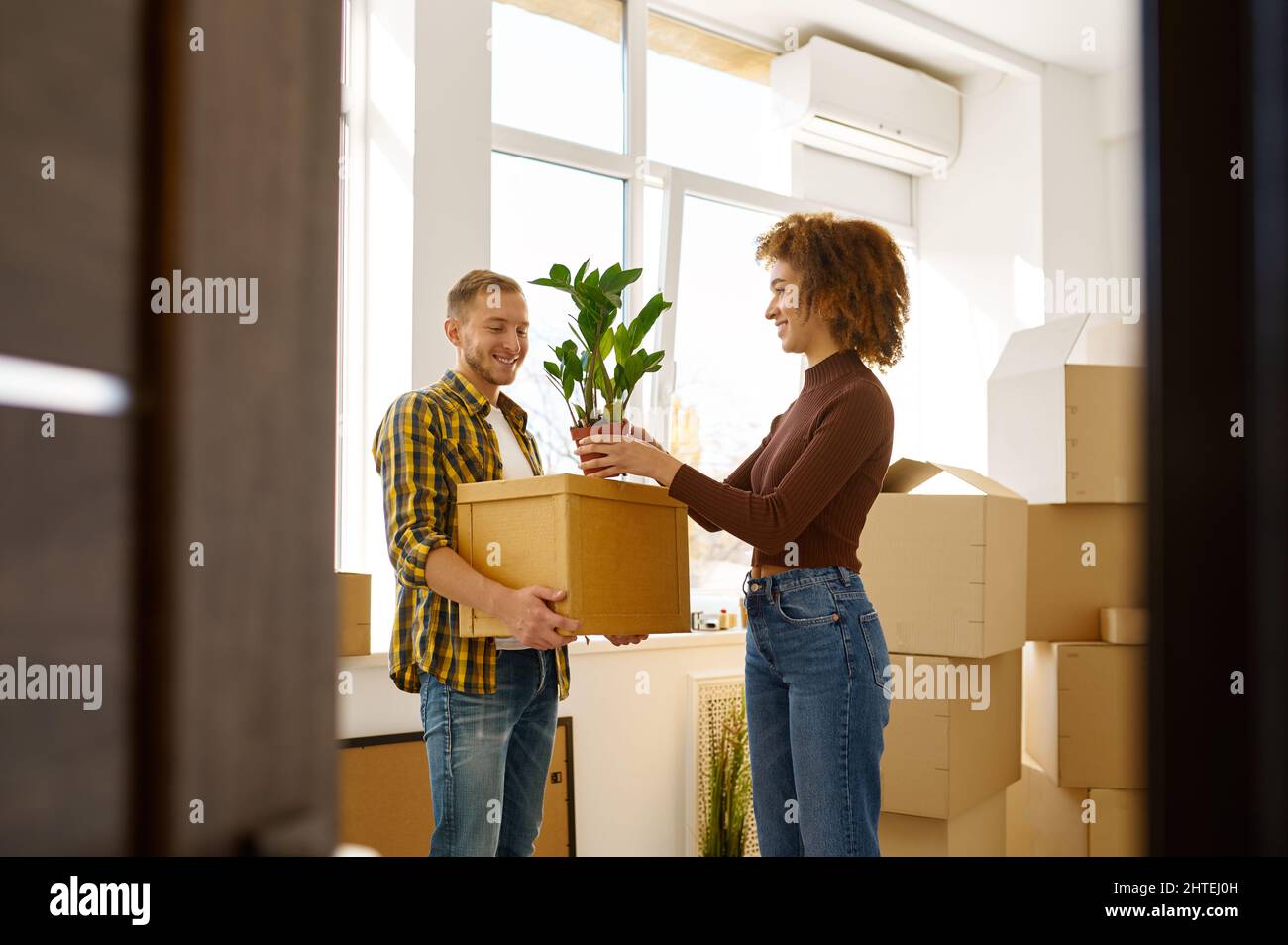 Couple on moving day carrying cardboard boxes Stock Photo