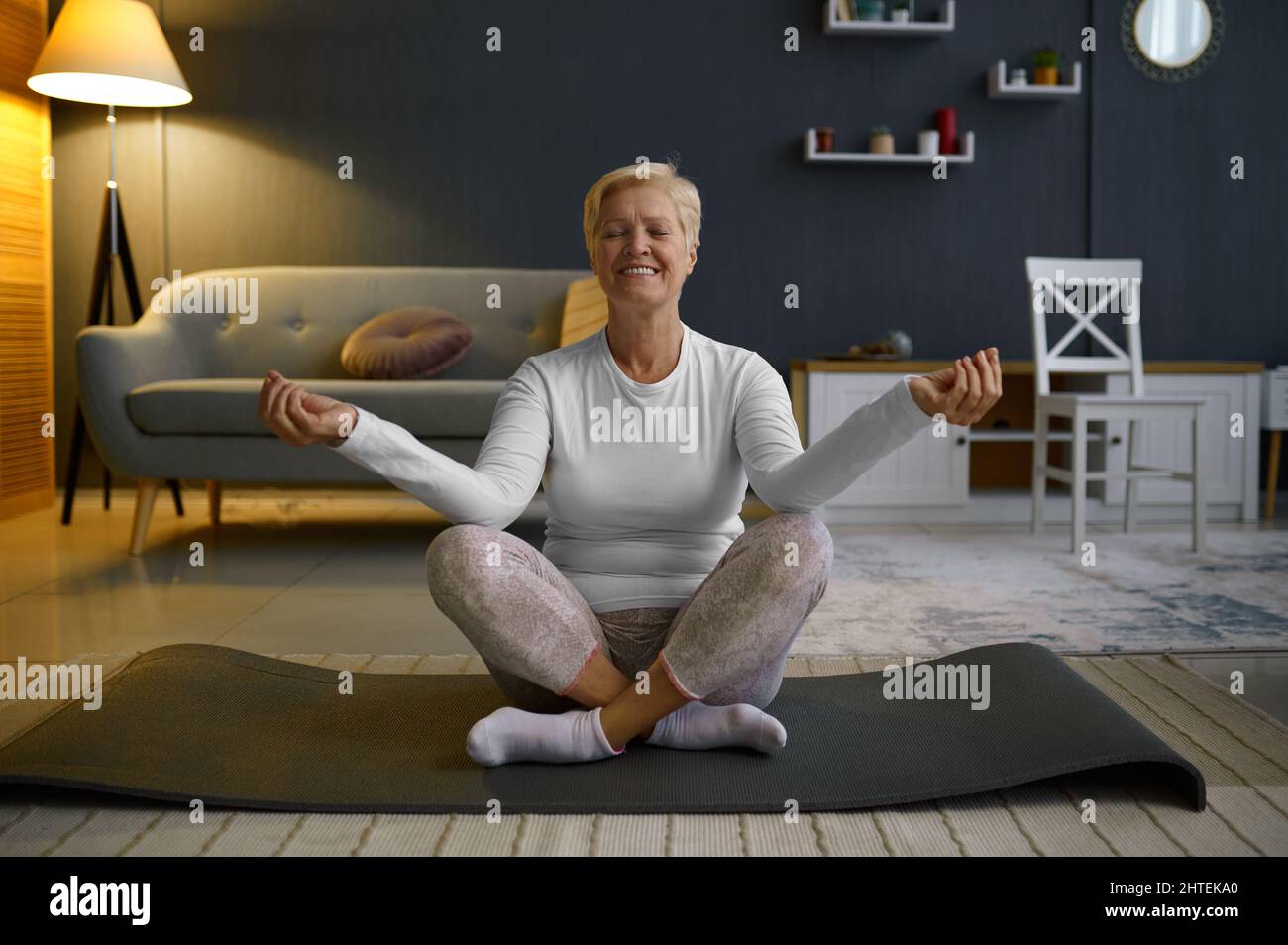 Mature woman practicing yoga in lotus pose Stock Photo