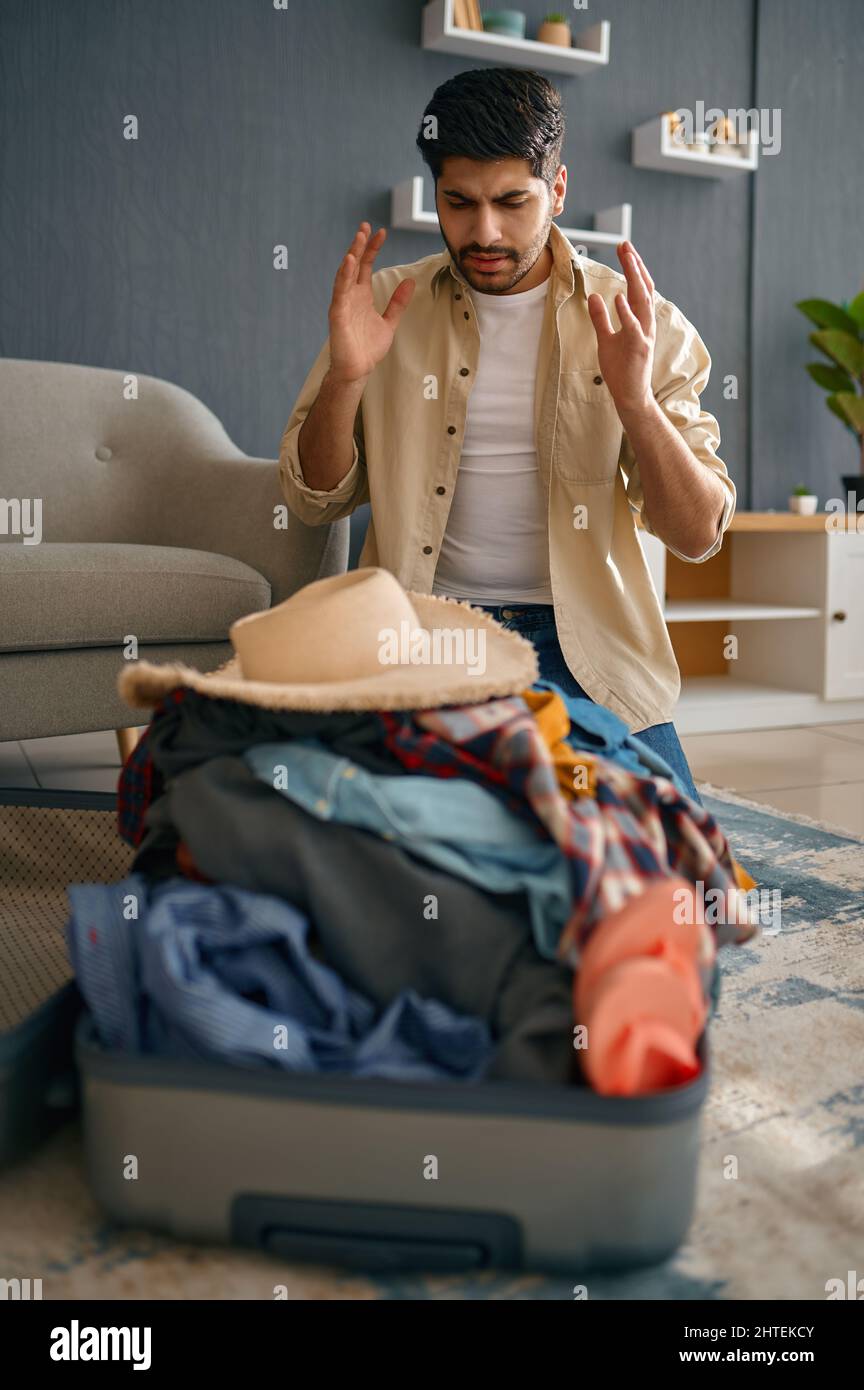 Man trying to fit clothes in suitcase Stock Photo Alamy