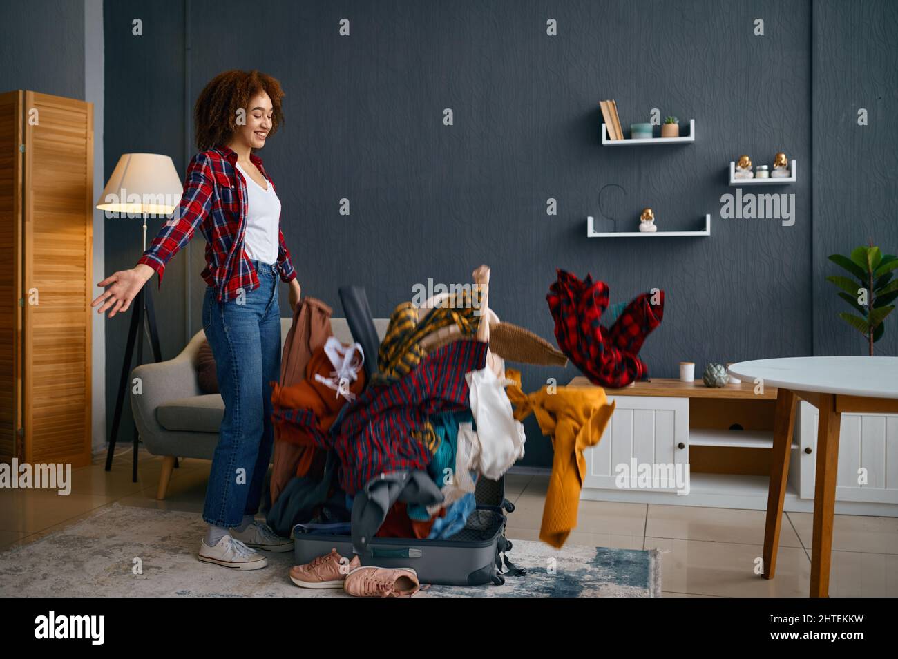 Woman throwing clothes heap into travel bag Stock Photo Alamy
