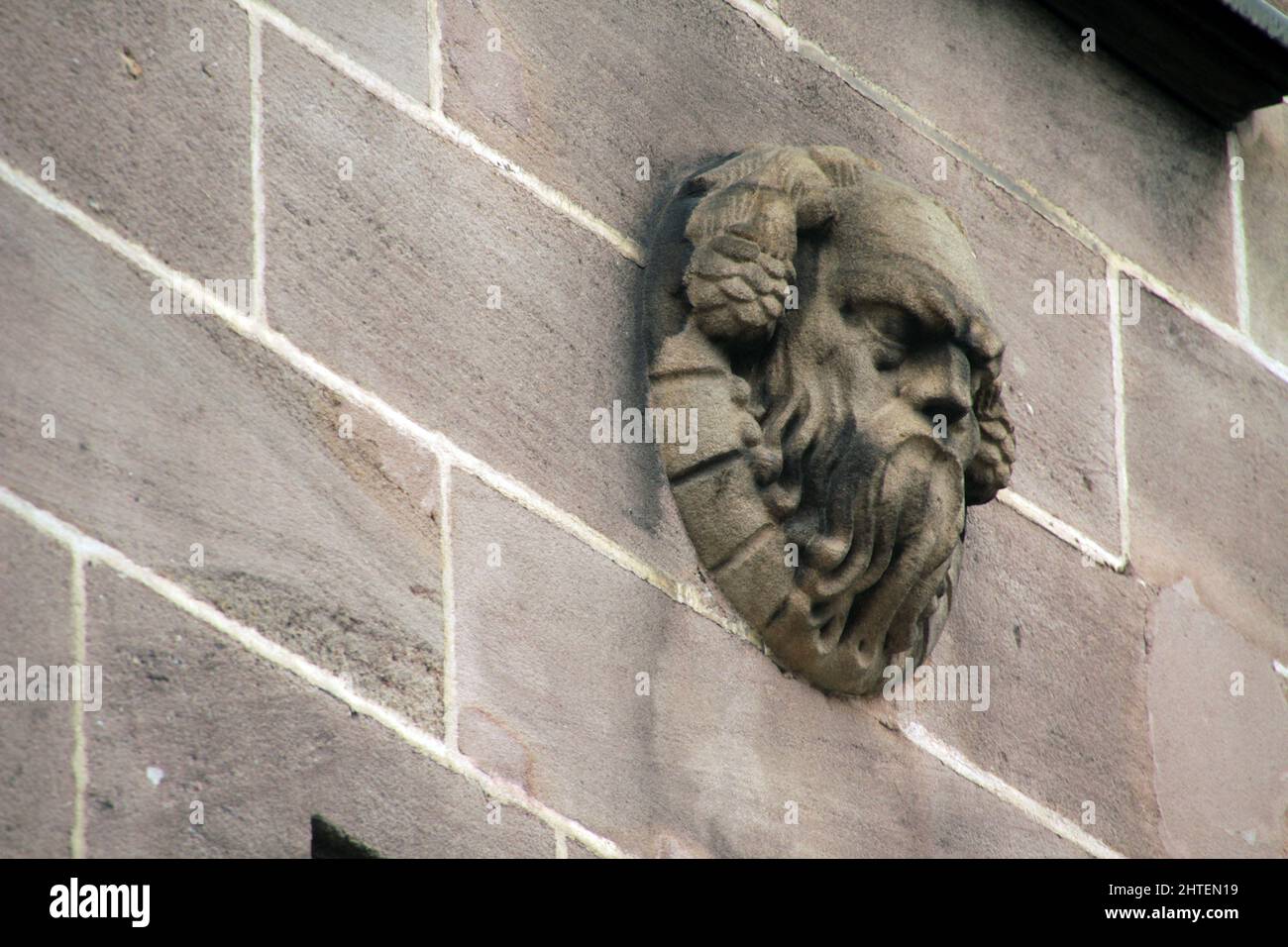 A closeup shot of a mascaron ornament carved on a building in Nuremberg, Germany Stock Photo
