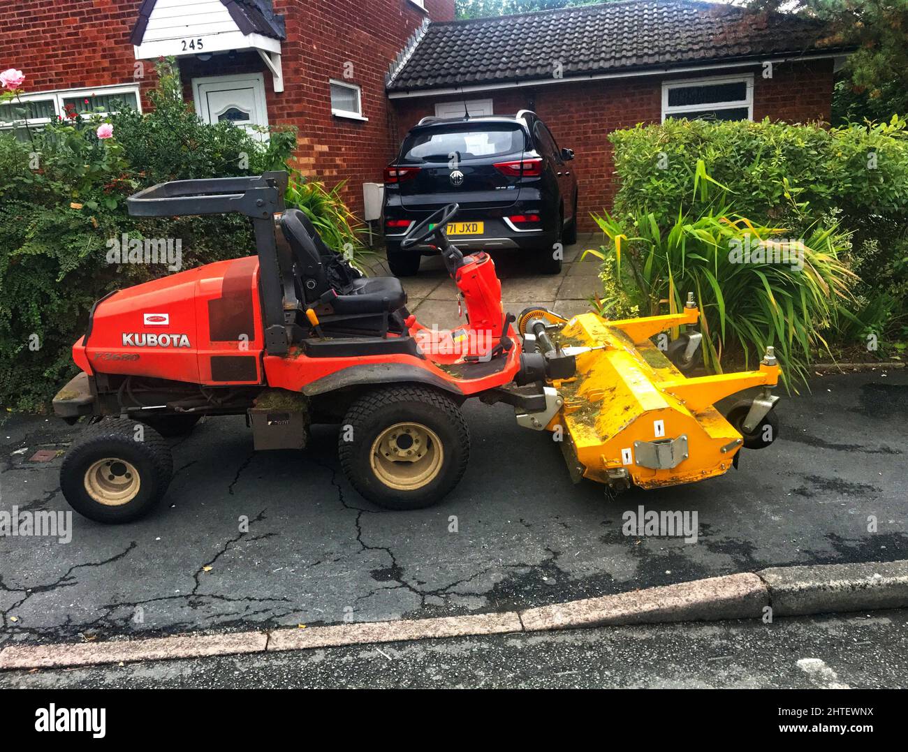 Tractor parked completely on the pavement and completely blocking the driveway forcing children to walk into a busy road Stock Photo