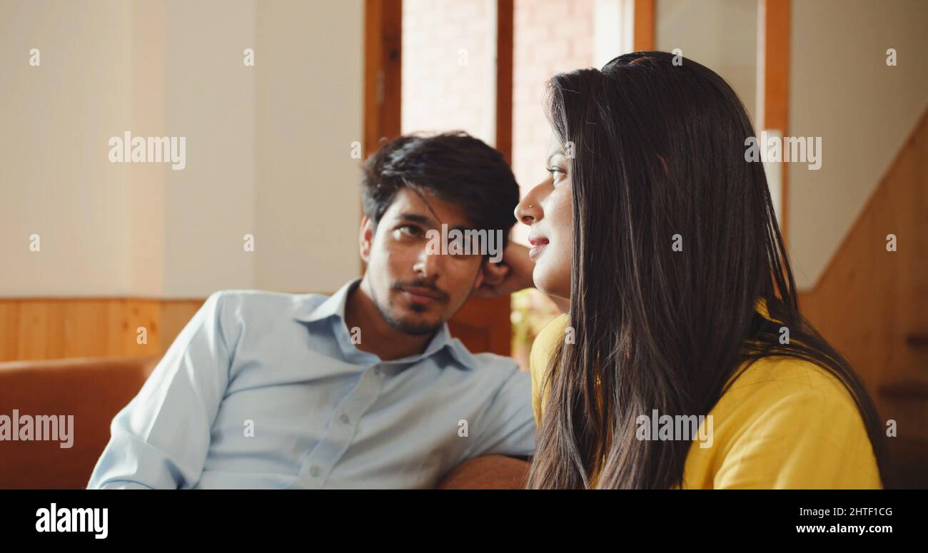 Indian couple, sitting on a couch indoors and talking Stock Photo Alamy