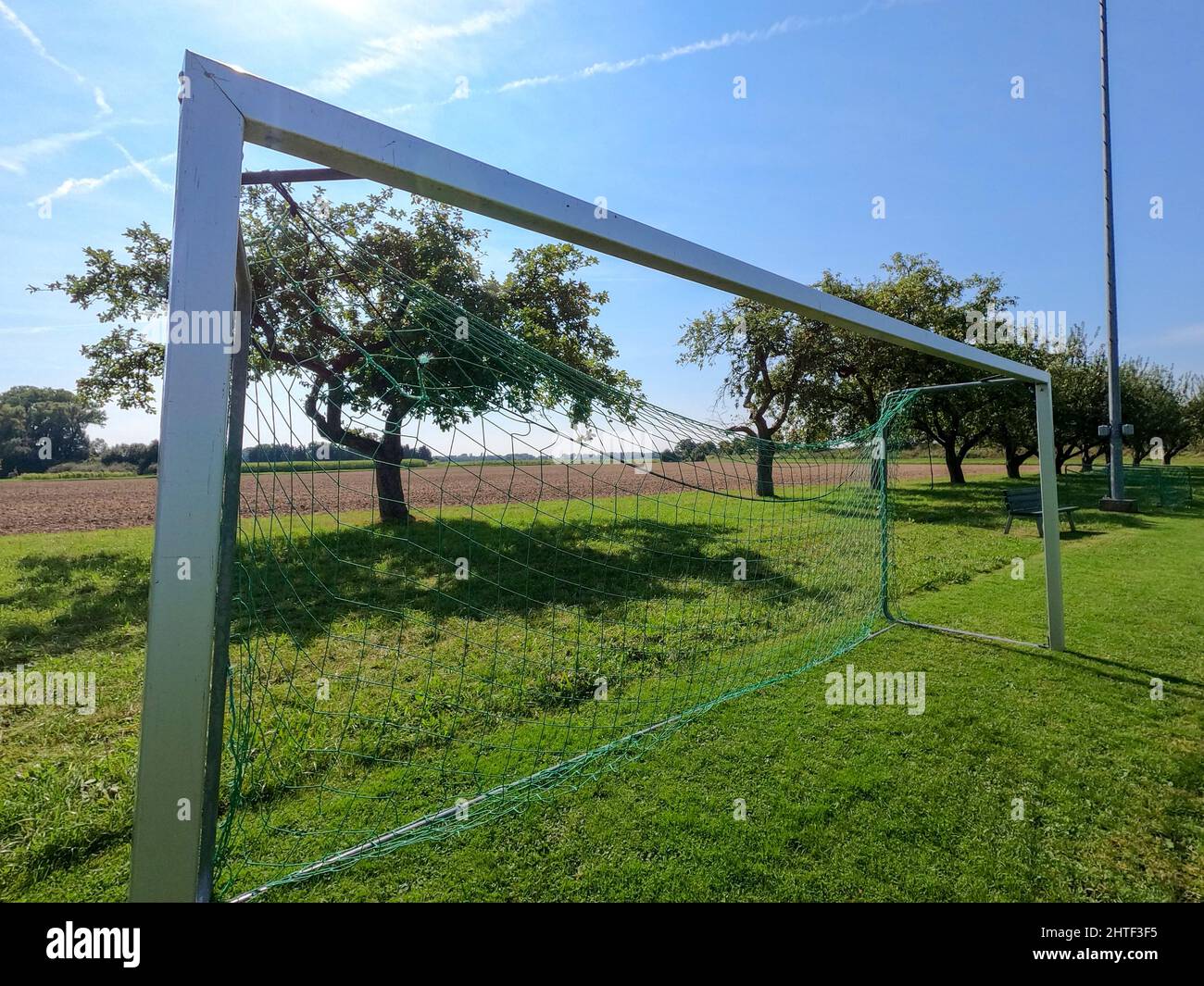 Soccer goal fence with a green net in a nice field on a sunny day Stock