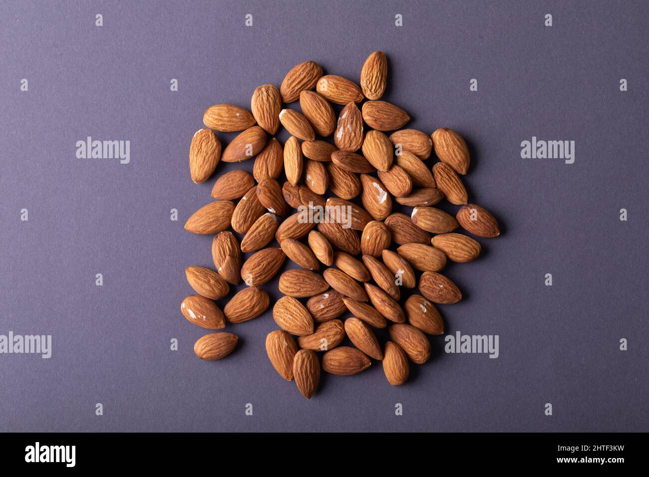 Overhead close-up shot of nutritious almonds on gray background Stock Photo