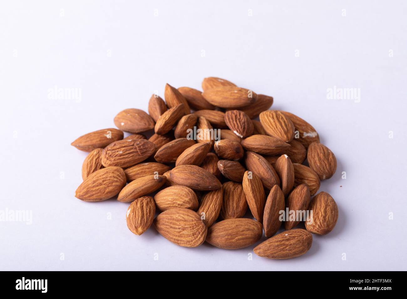 Close-up of nutritious almonds on white background Stock Photo
