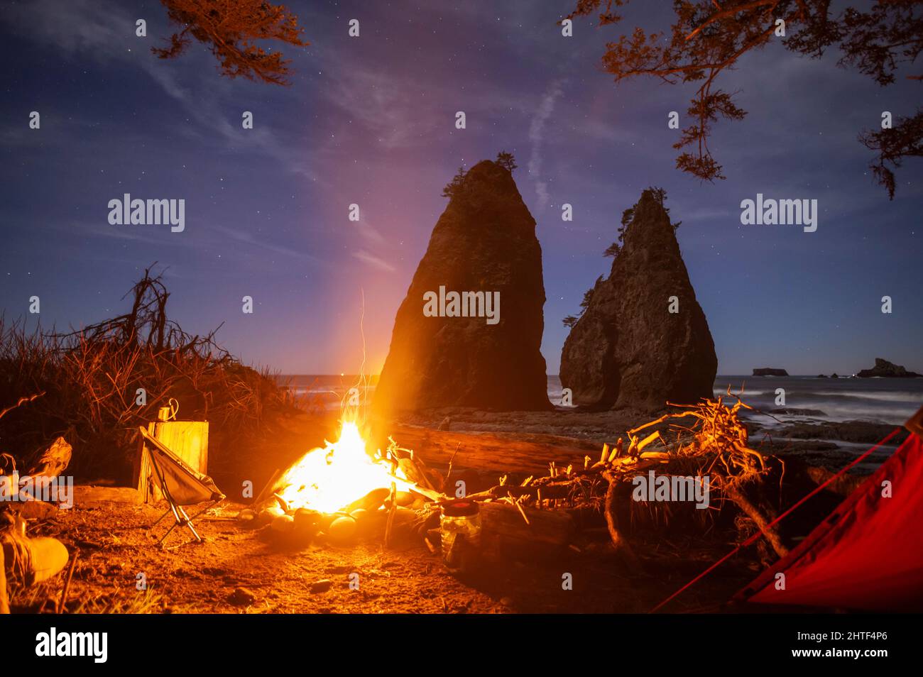 Campfire glowing in campsite on the Olympic National Park Coast Stock Photo
