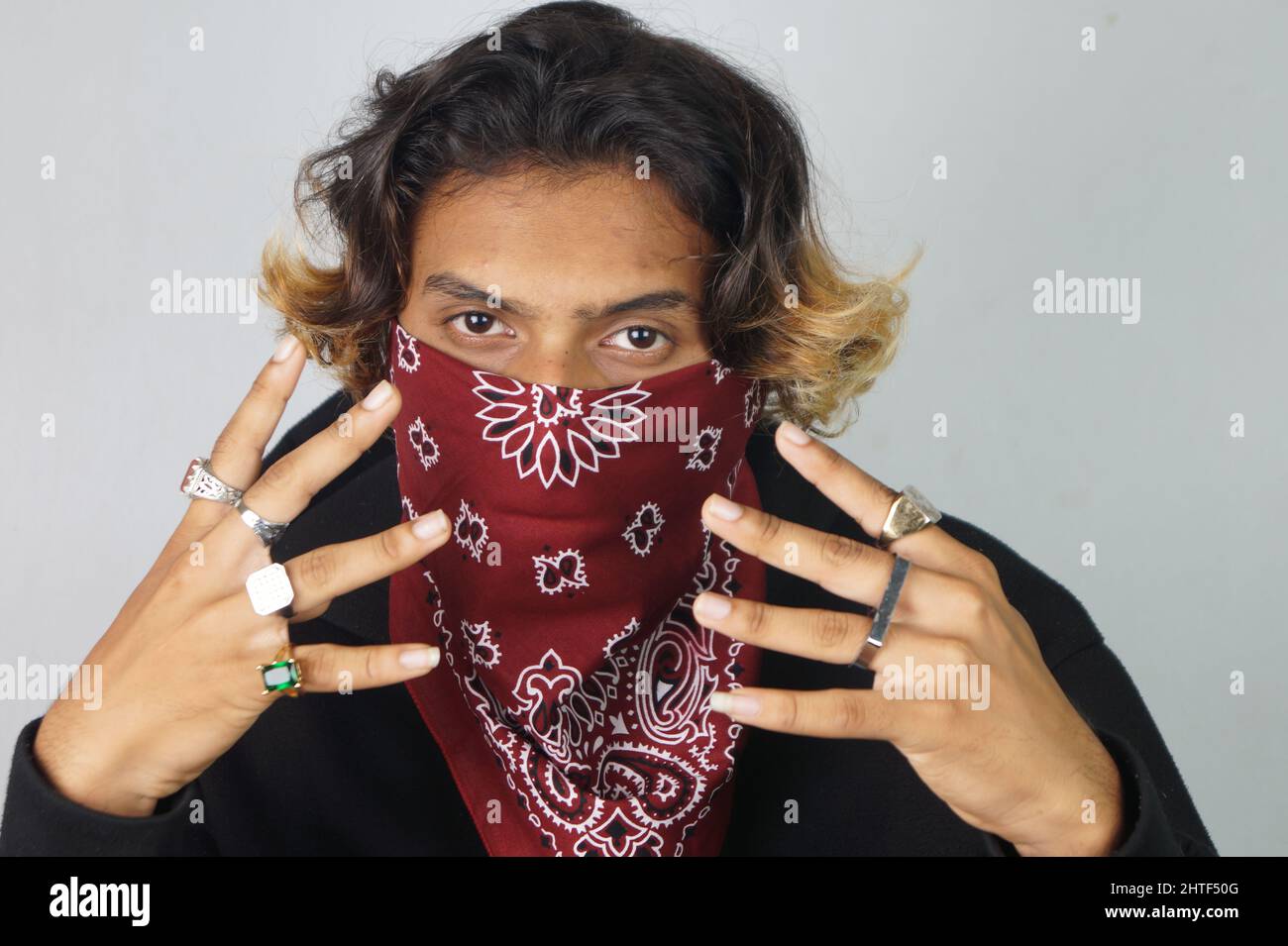 Young thug Indian male with a bandana covering his face and rings on his fingers Stock Photo Alamy