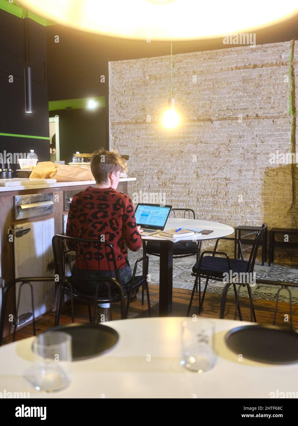 Vertical photo of a female manager working with a laptop on a restaurant Stock Photo