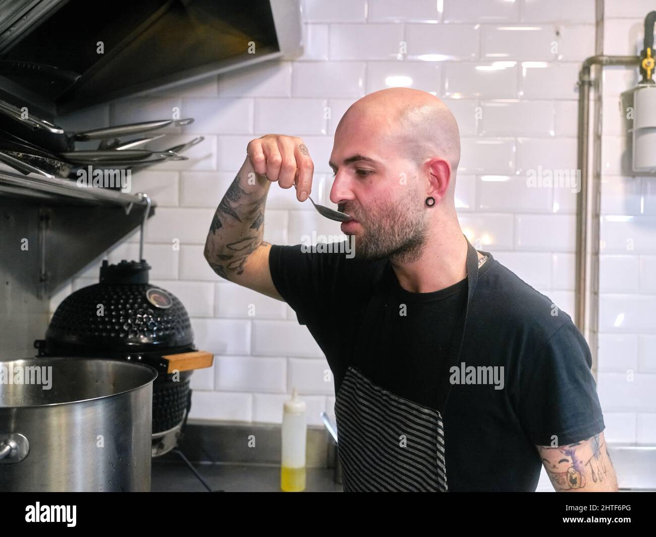 Chef cook tasting food with wooden spoon at the restaurant kitchen Stock  Photo - Alamy