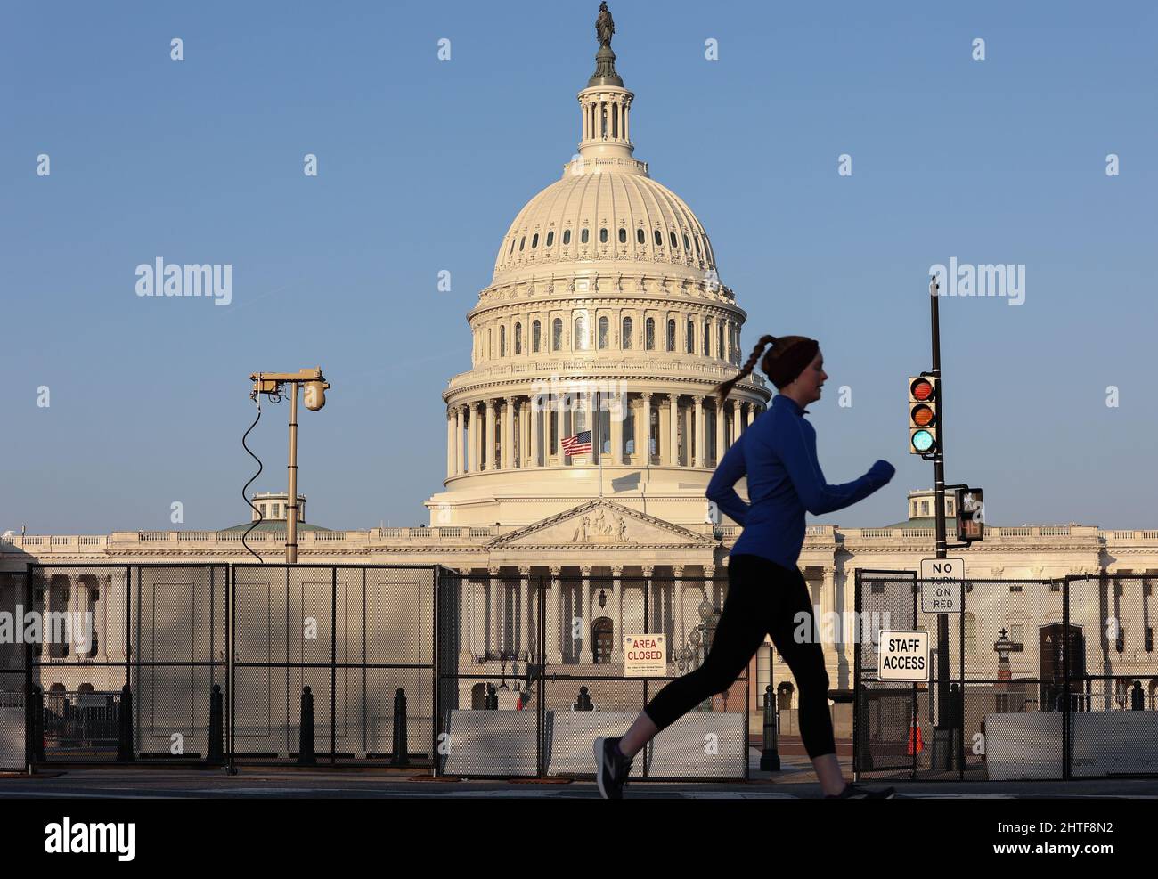 Washington, United States. 28th Feb, 2022. A jogger runs past the US Capitol Building in Washington DC on Monday, February 28, 2022. Fencing was erected by the US Capitol Police once before following the January 6, 2021 riots and was reinstalled this year prior to the March 1, 2022 State of The Union address by President Biden and the arrival of a trucker caravan coming to Washington DC to protest COVID restrictions. Photo by Jemal Countess/UPI Credit: UPI/Alamy Live News Stock Photo