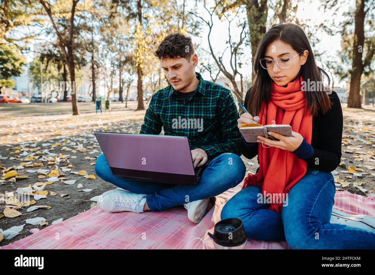 young couple using laptop to work outdoors Stock Photo