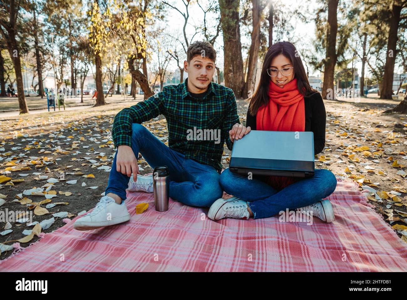 young couple using laptop to work outdoors Stock Photo