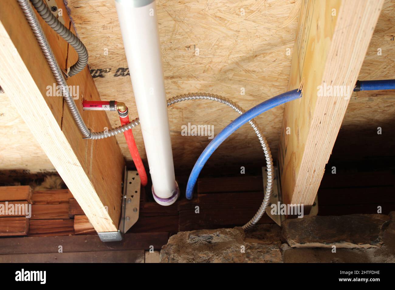 Plumbing Pipes and Electrical Wire In and Around Basement Floor Joists