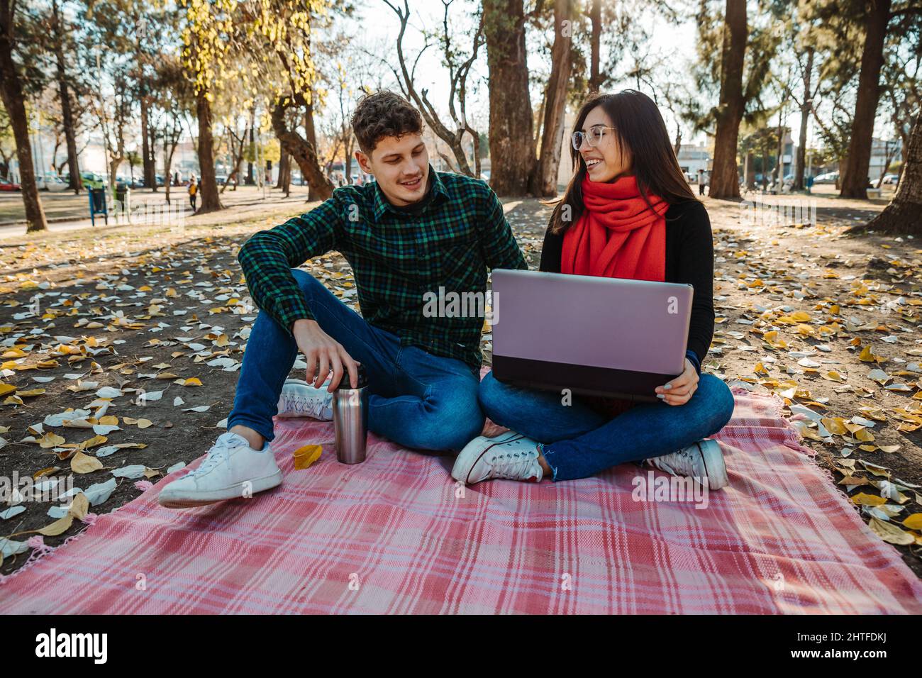 young couple using laptop to work outdoors Stock Photo