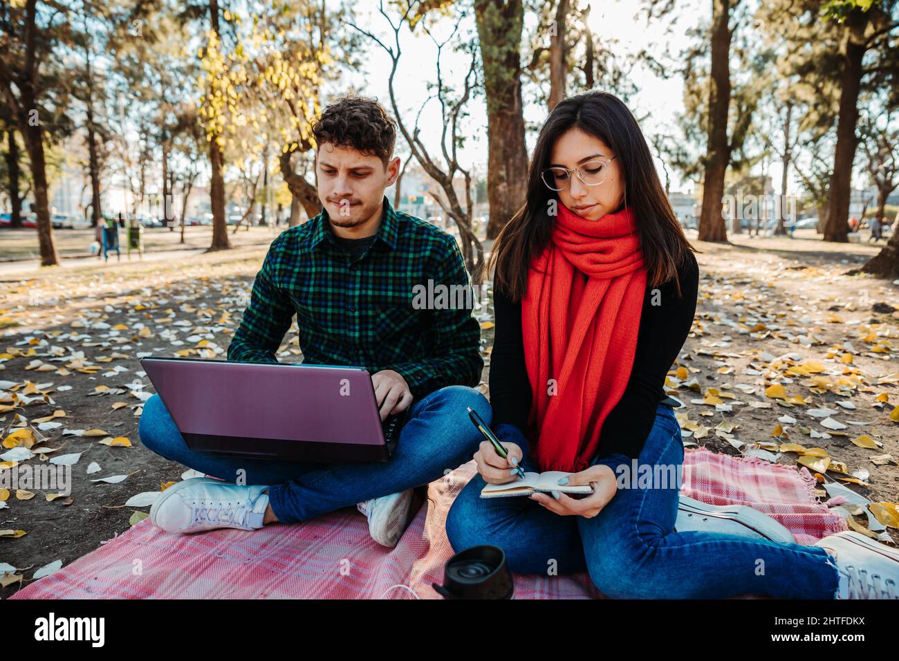 young couple using laptop to work outdoors Stock Photo