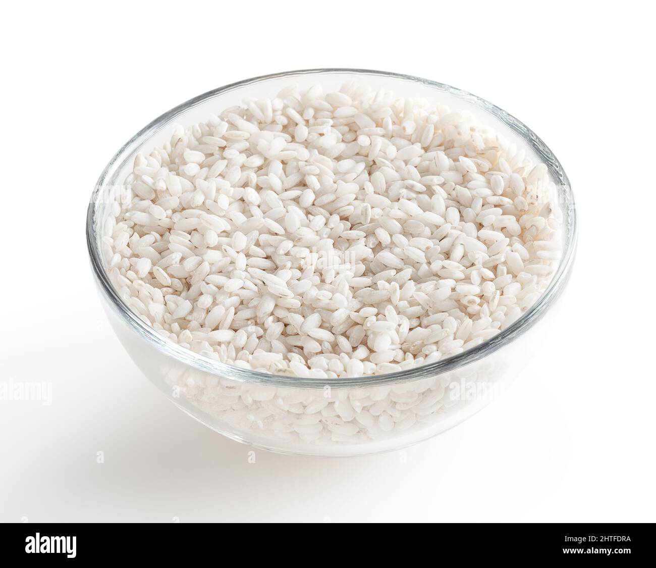 Uncooked arborio rice in glass bowl isolated on white background with clipping path Stock Photo