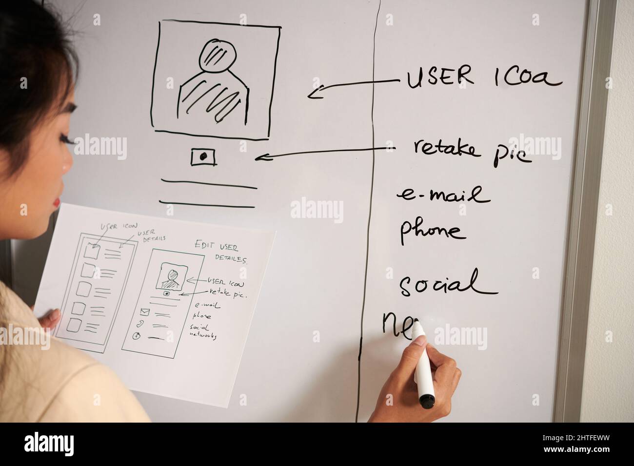 UX designer writing ideas for improving mobile application interface on ...