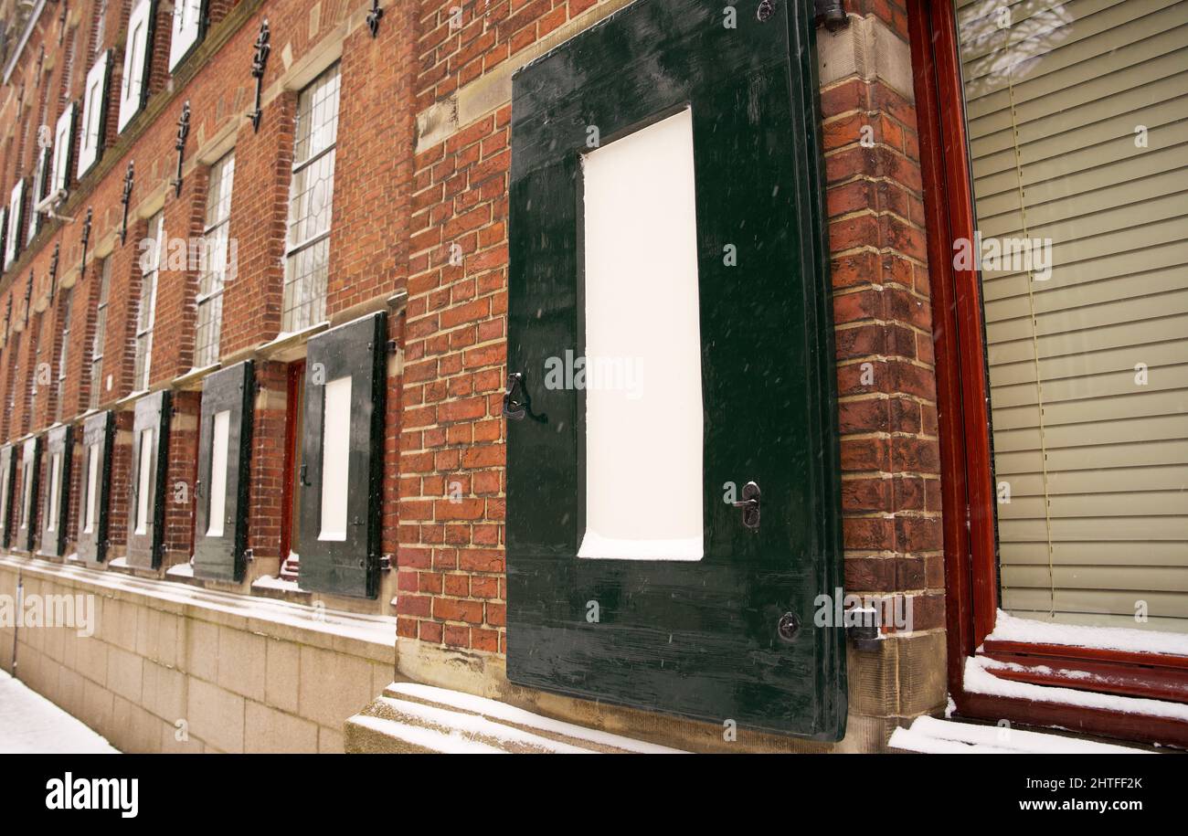 Window with shutters on an ancient building of the province of Groningen with some snow in the winter Stock Photo