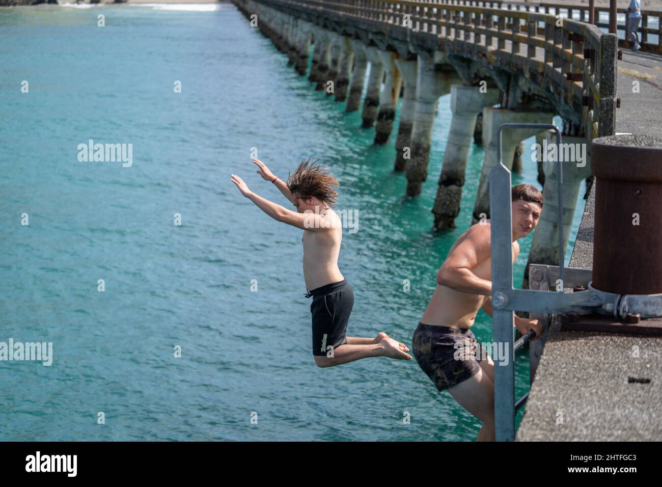 Tolaga Bay New Zealand - February 5 2022; Local boys jumping of Tolaga Bay Wharf Stock Photo