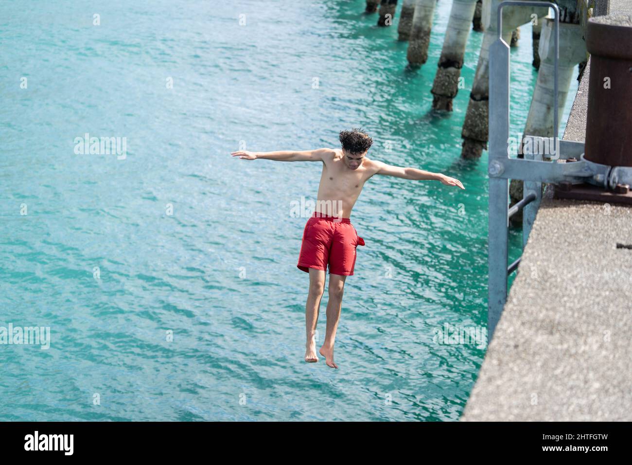 Tolaga Bay New Zealand February 5 2022; Local boy in red togs jumping