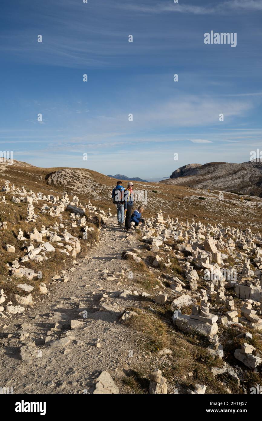 Vertical shot of a group of people hiking in the Dolomites mountains in ...