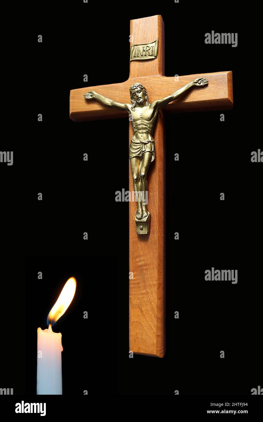 Lit candle ahead of wooden cross with body of Christ Stock Photo Alamy