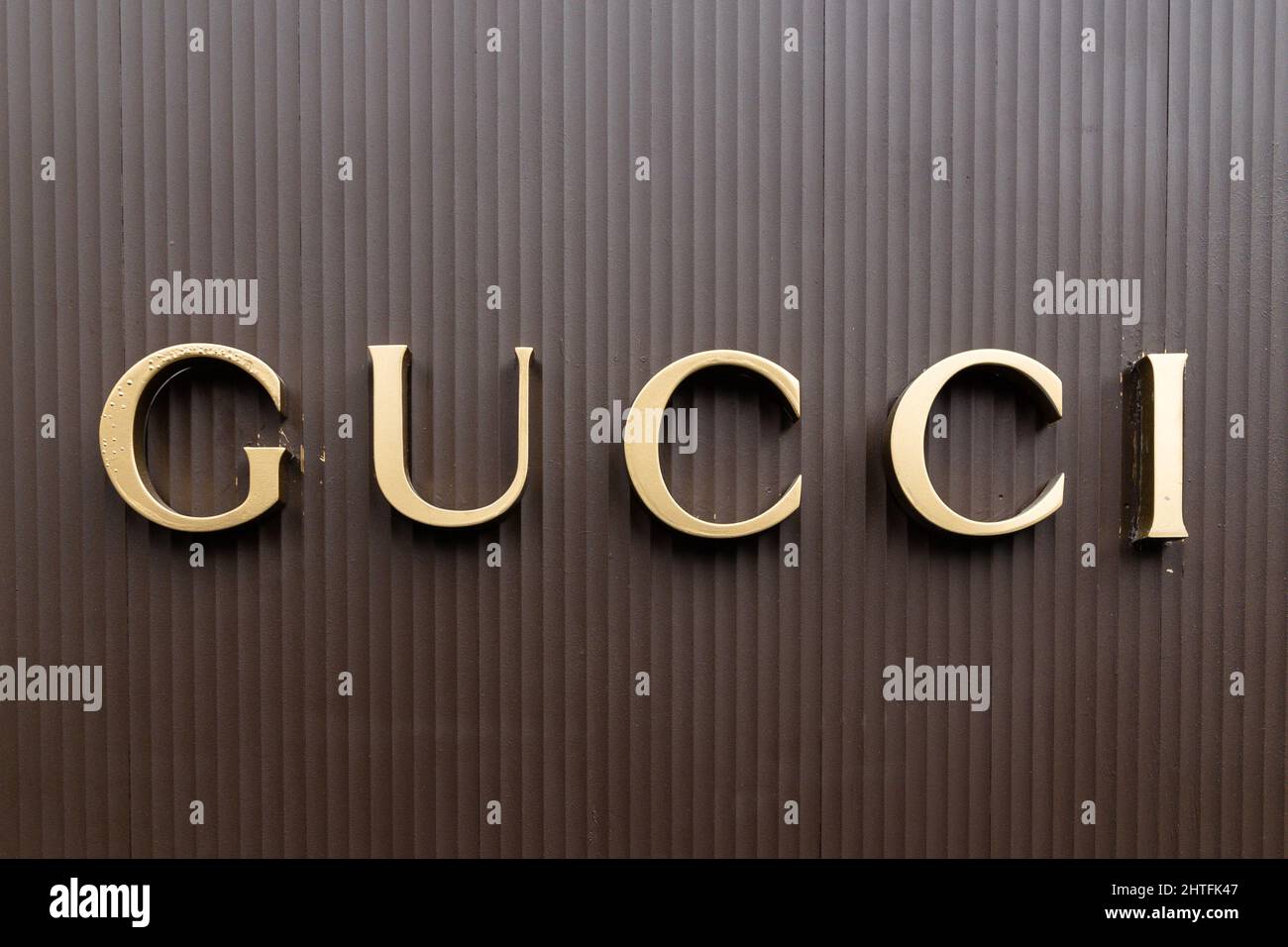 Gucci logo on brown background golden letters Stock Photo - Alamy