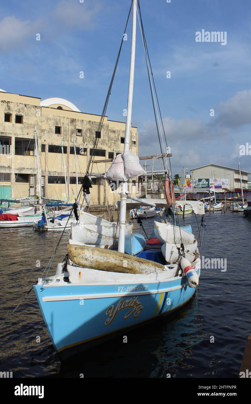 BELIZE CITY, BELIZE - JULY 6, 2016 single fishing boat moored at the Swing Bridge with fishermen and boats from Sarteneja Stock Photo