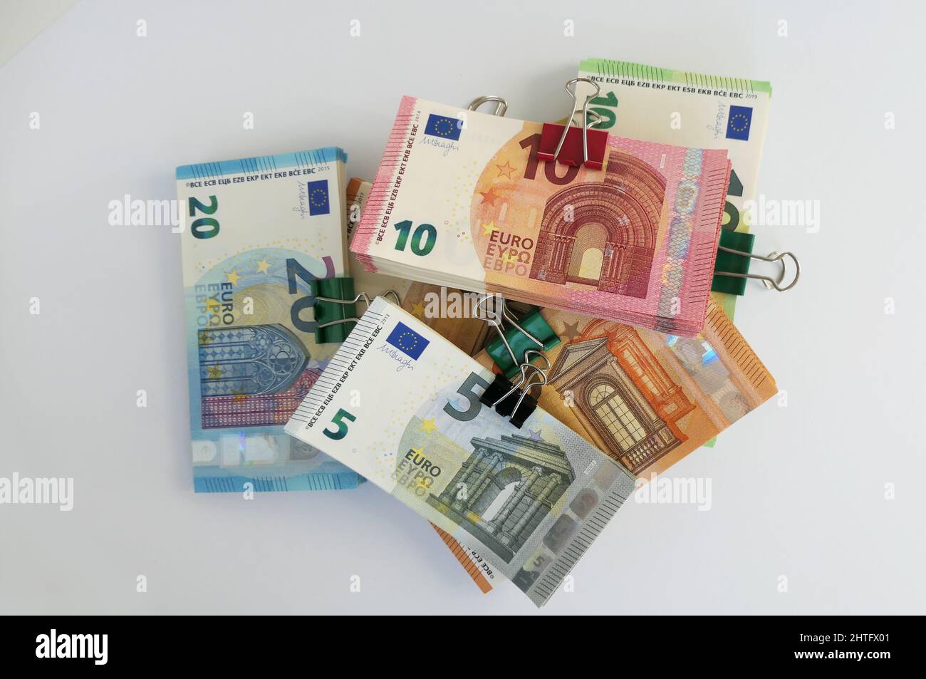 stacks of euro banknotes stuck together by a letter foldback clip piled Stock Photo